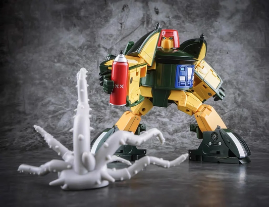 A yellow and dark green toy robot figure posed over a white multi-limbed creature, set against a dark textured studio backdrop.