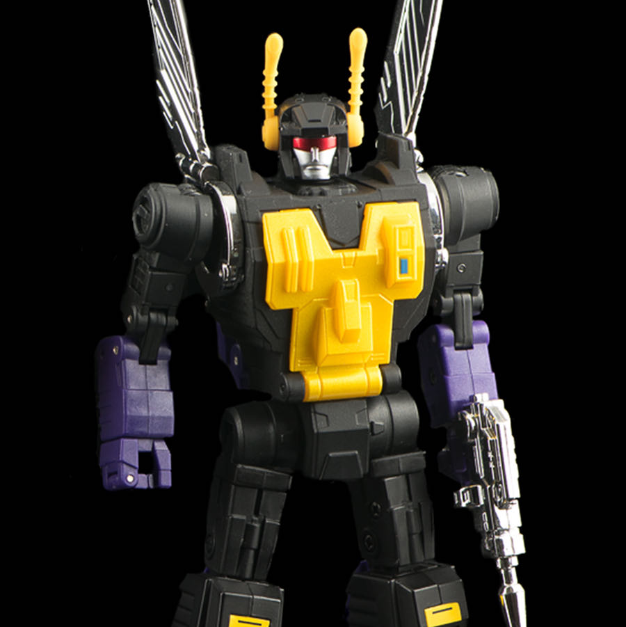 A toy robot figure with a black body, bright yellow chest and head details, purple hands and feet, and large metallic silver wing-like structures on the back, posed against a solid black background.