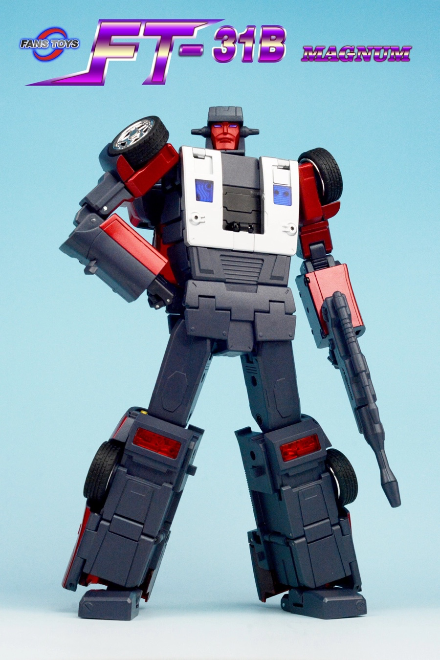 FT-31B Megamute action figure from Transformers, shown in robot mode against a light blue gradient background. The figure is primarily dark gray and white with red accents and black tires on its shoulders and arms.