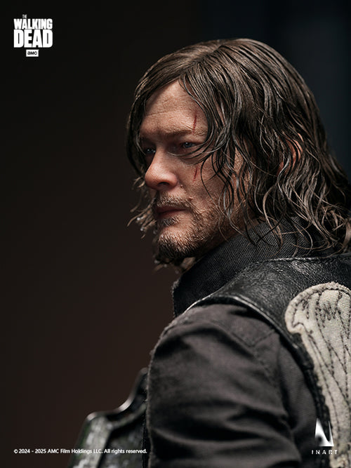 A close-up portrait of a collectible figure or statue of Daryl Dixon from The Walking Dead, shown in profile with long dark hair, a beard, and a black leather vest with a wing patch on the back, against a dark studio background. The Walking Dead logo appears in the top-left corner.