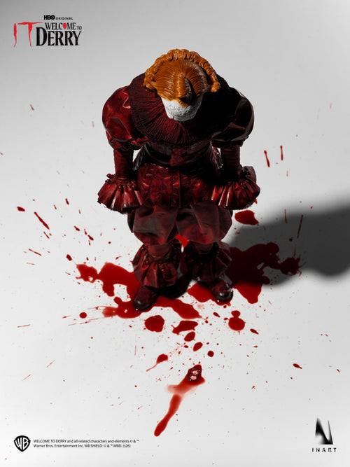 A horror collectible figure of Pennywise the Clown from IT, kneeling in a blood-splattered pose on a white background. The figure has orange hair, a white mask, and a dark red and black clown suit.