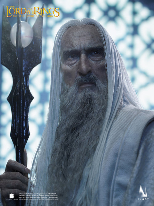 A highly detailed collectible figure of Saruman from Lord of the Rings: The Rings of Power, featuring long white hair and beard, holding a dark staff, with the Inart brand logo in the bottom right corner.