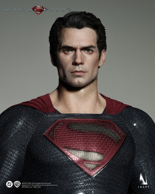 A highly detailed collectible figure of Superman from Batman v Superman, shown from the chest up against a neutral gray background. The figure features Henry Cavill's likeness with realistic skin texture, dark hair, and a textured black suit with a red S-shield and red cape.