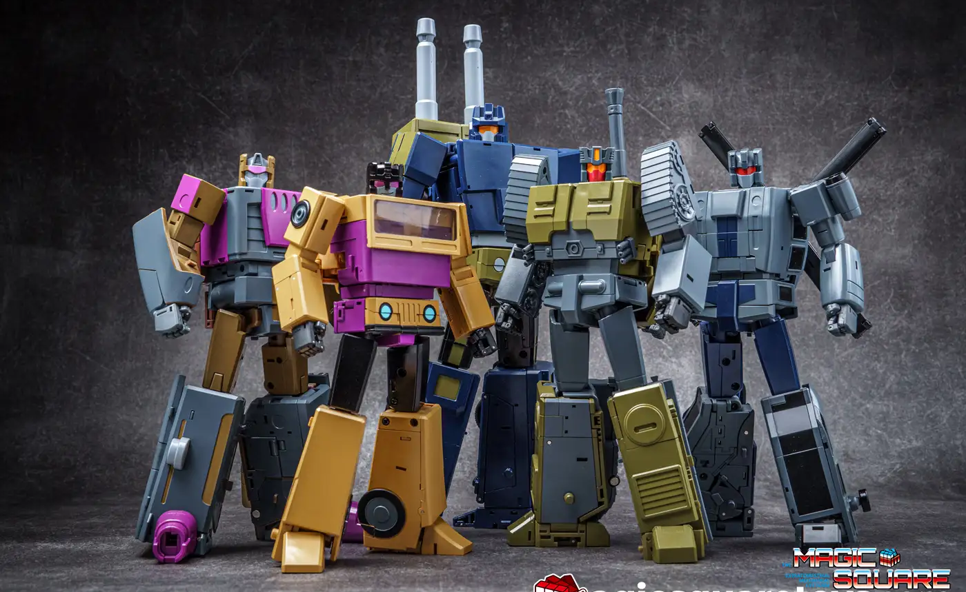 Four Transformers-style robot action figures posed together against a dark textured studio background. The figures are primarily blue, yellow, gray, and purple, with metallic and industrial details.